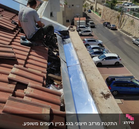 אדם עובד על גג רעפים עם יריעת מתכת